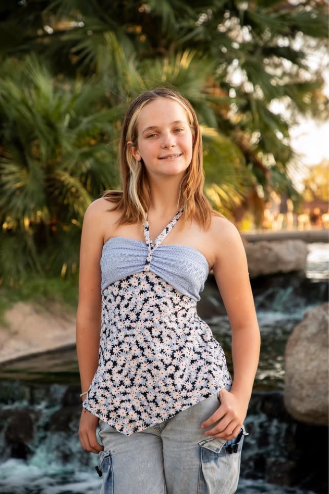 Olivia Hathaway smiling outdoors by a park waterfall